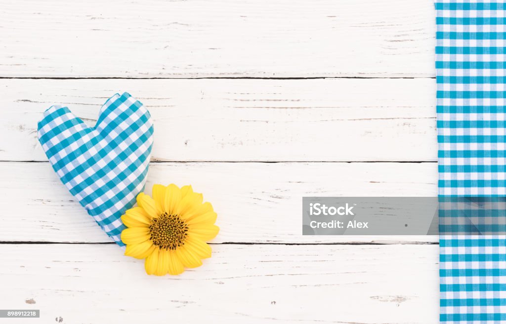 Baby boy birthday greeting card background with blue heart and blossom Cute blue heart with yellow flower on white wooden background with copy space Baby Shower Stock Photo