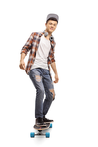 Full length portrait of a teenage hipster riding a longboard isolated on white background