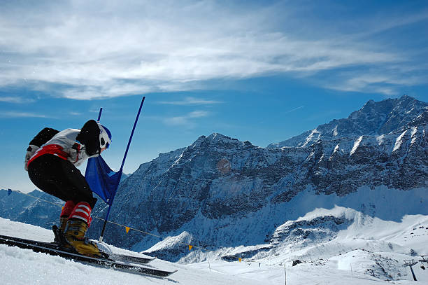 A person skiing down a hill in the wintertime stock photo