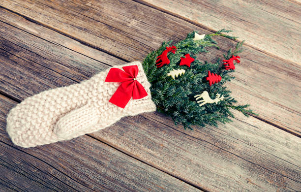 istock Mitten with fir branches on a wooden background. 898929378