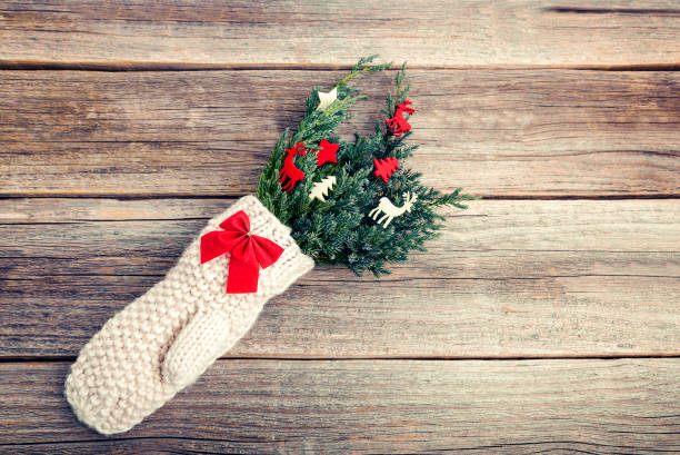 istock Mitten with fir branches on a wooden background. 898929426