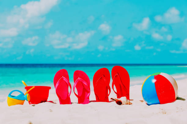 istock Colored flip-flops, toys and diving mask at beach 898929566