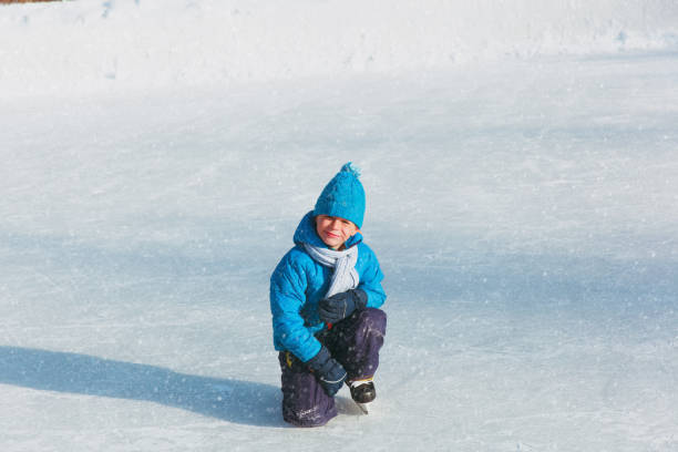 istock cute little boy learning to skate in winter 898932244