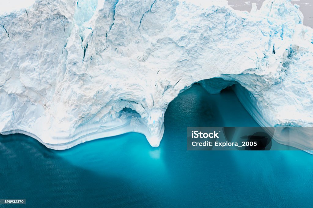 Aerial view of Arctic Icebergs on Arctic Ocean in Greenland Arctic Icebergs Greenland in the arctic sea. You can easily see that iceberg is over the water surface, and below the water surface. Sometimes unbelievable that 90% of an iceberg is under water Beauty In Nature Stock Photo