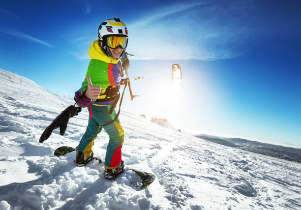 istock Happy lady snowboarder with snow kite 898932884