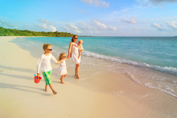 istock mother with little son and daughters walk on beach 898932948