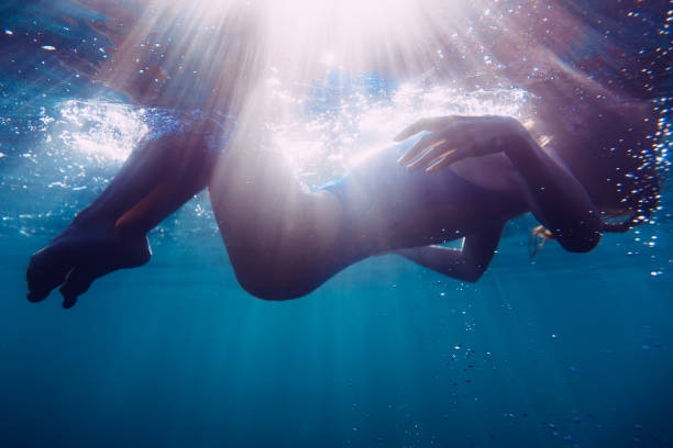 istock Woman floating underwater in sea 898936790