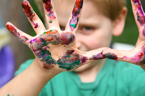 istock Boy Playing Peek-a-boo from behind paint-covered Hands 89893905