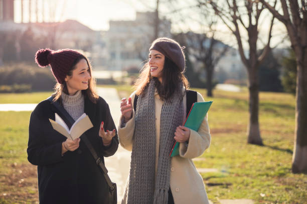 Happy Female Students In Public Park Cheerful young university students on city street exchange student stock pictures, royalty-free photos & images