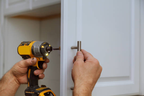 istock Hand on handle installation door in kitchen cabinet with a screwdriver 898942314