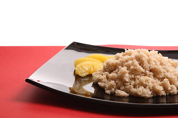 Porridge with peach slices on the black plate stock photo