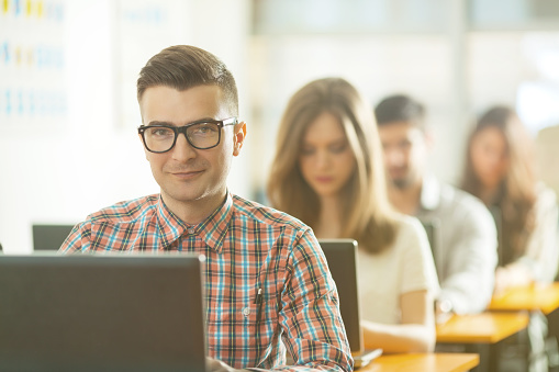 Portrait of handsome young nerd studying Computer Sciences