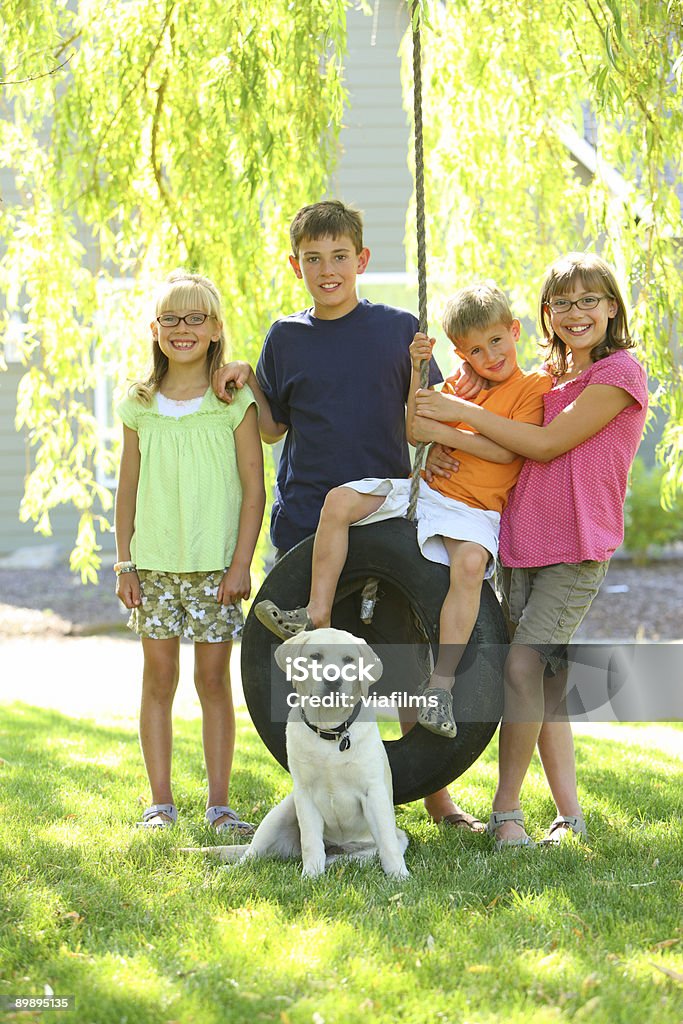 portrait de groupe d'enfants et chien de Balançoire pneu - Photo de Animaux de compagnie libre de droits