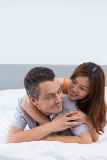 istock Happy young couple lying in bed and hugging 898951456