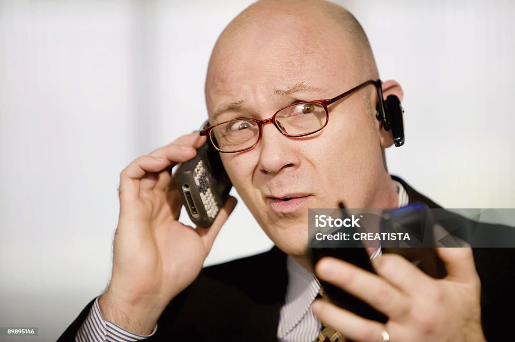Uomo d'affari con i telefoni cellulari - Foto stock royalty-free di Abbigliamento da lavoro