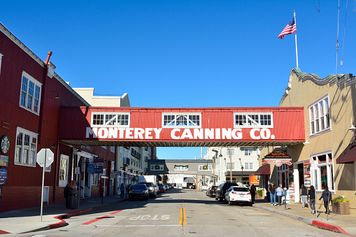 Monterey, California, United States of America - November 29, 2017. Street view in the Cannery Row district of Monterey, with historic buildings, wooden skywalk, cars and people.