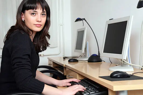 Young woman sitting by computer