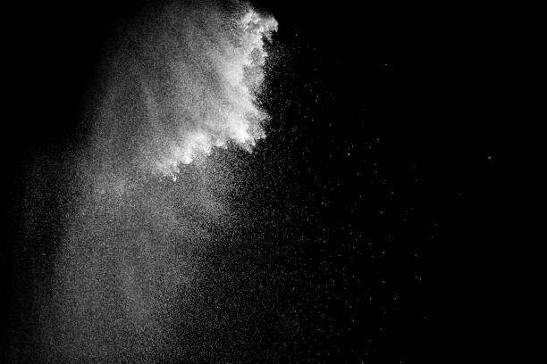 istock Freeze motion of white particles on black background. White granule explosion. Abstract white dust overlay texture. 898955300