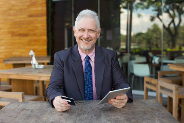 istock Smiling Senior Business Man with Credit Card 898955324