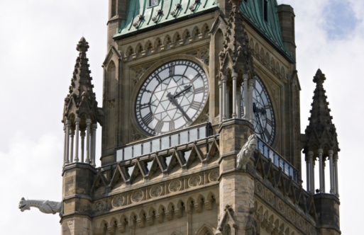 A close-up of the Big Ben clock face illuminated by the setting sun.