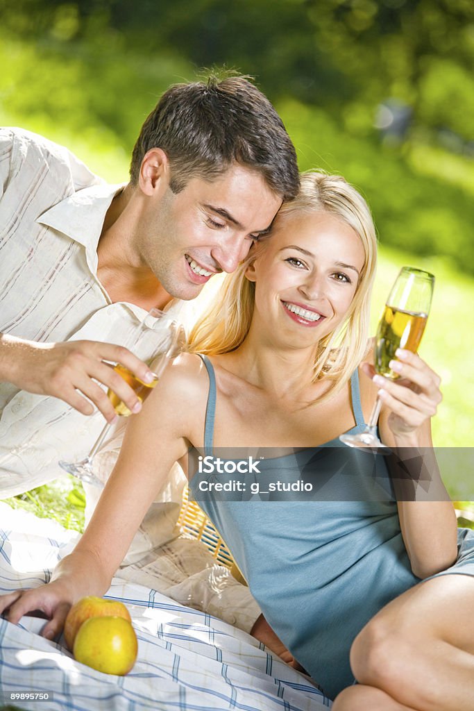 Young happy couple celebrating with champagne at picnic  Adult Stock Photo