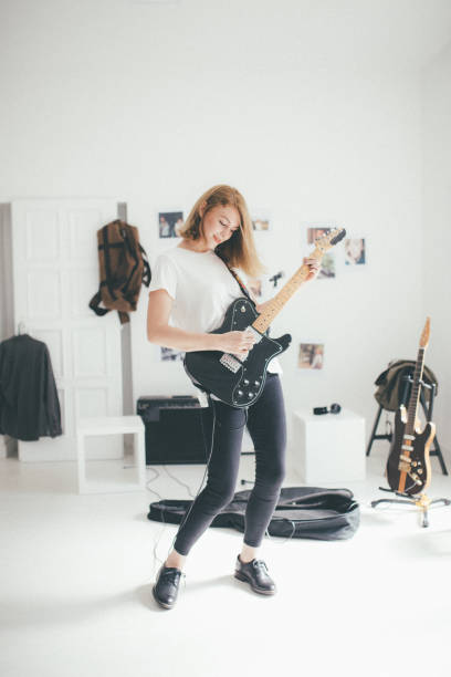 istock Beautiful young woman playing guitar 898959592