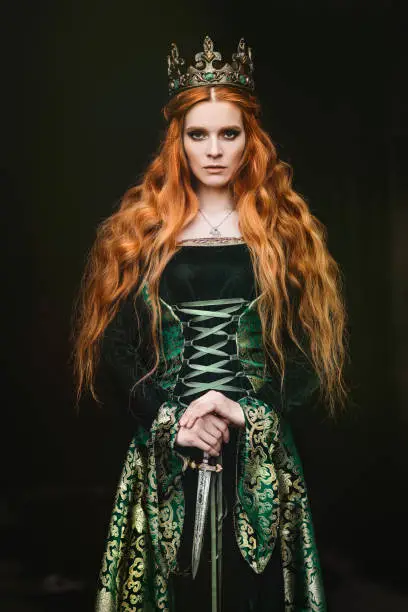 Portrait of a beautiful red-haired woman in green medieval dress