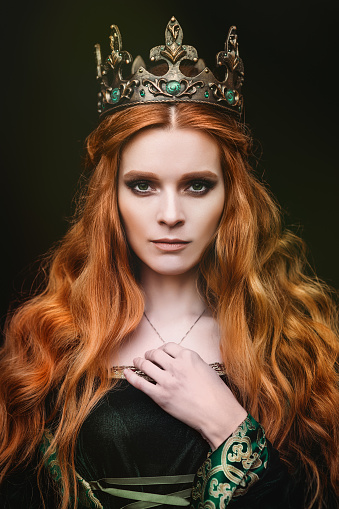 Red-haired woman in a green medieval dress near the castle
