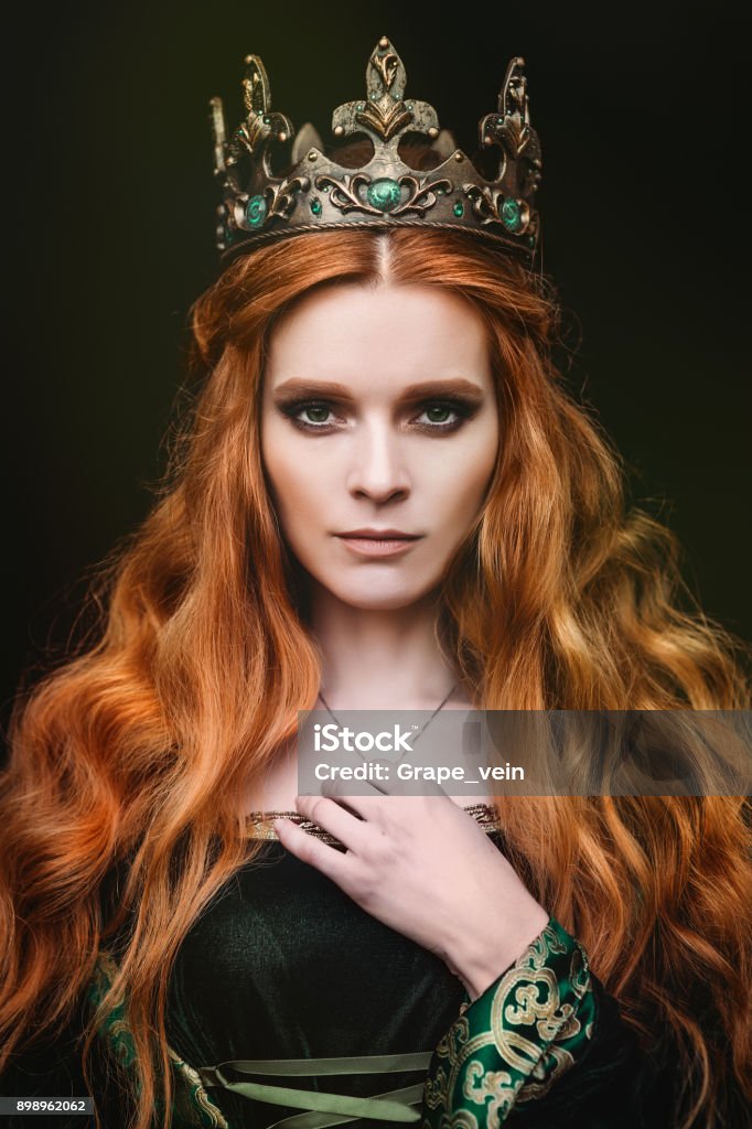 Ginger queen near the castle Red-haired woman in a green medieval dress near the castle Queen - Royal Person Stock Photo