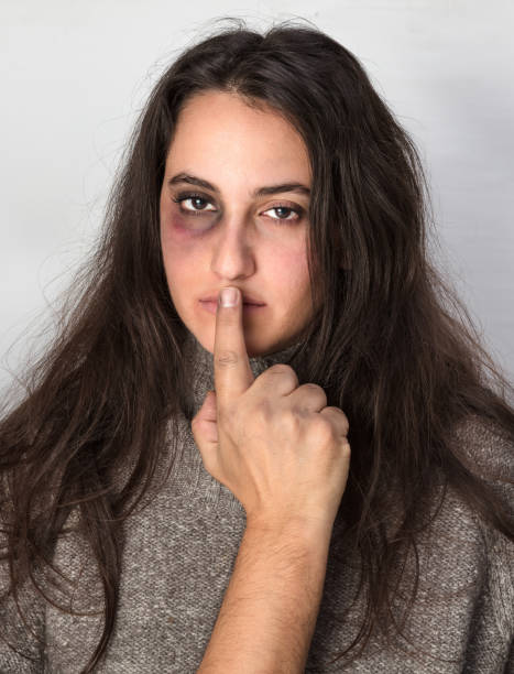 Abusive man silencing a woman with his hand stock photo