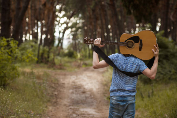 istock Talented guitarist playing forest hiking concept. 898963180