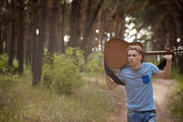 istock Tired guitarist man walk forest concept. 898963290