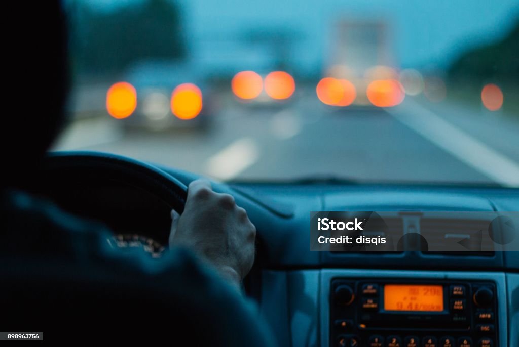 Hands on steering wheel man driving a car by night Driving Stock Photo