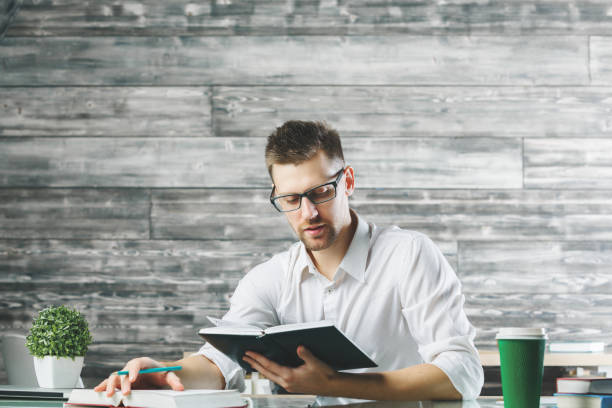 istock European man reading book at workplace 898966170