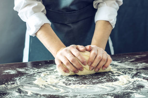 istock The chef in black apron makes pizza dough with your hands on the table 898971006