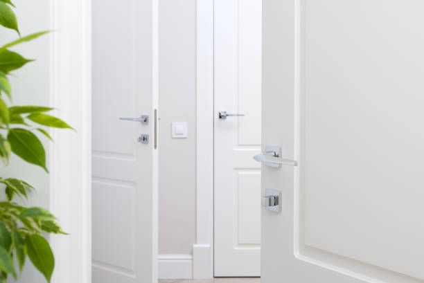 istock Modern chrome door handle on white door. Beautiful interior closeup 898971668