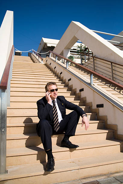 Businessman with cellular on the stairs stock photo