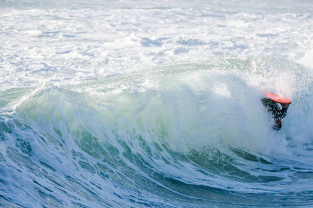 istock Bodyboarder surfing ocean wave 898980158