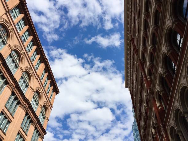 istock Cloudy blue sky between buildings in New York 898980598