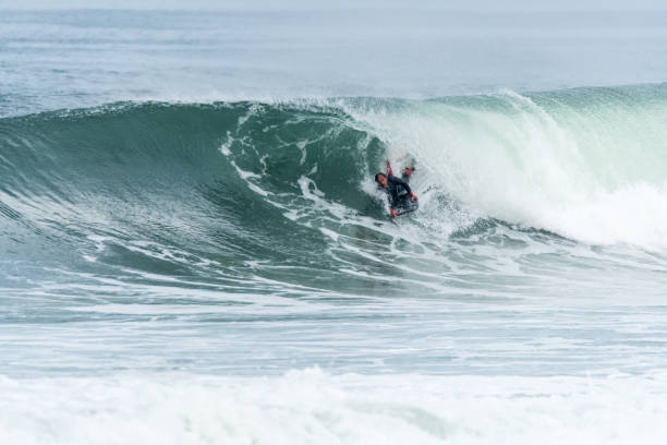 istock Bodyboarder surfing ocean wave 898980688