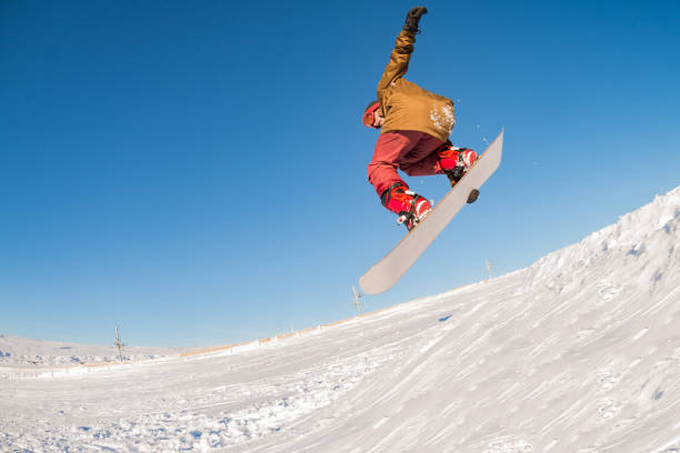 istock Snowboarder jumping against blue sky 898983318