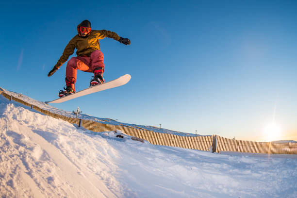 istock Snowboarder jumping against blue sky 898983438