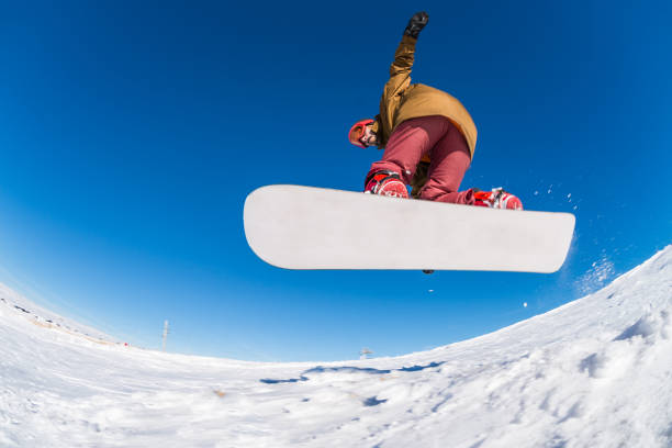istock Snowboarder jumping against blue sky 898983766
