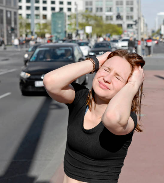 istock woman covers her ears 898987428