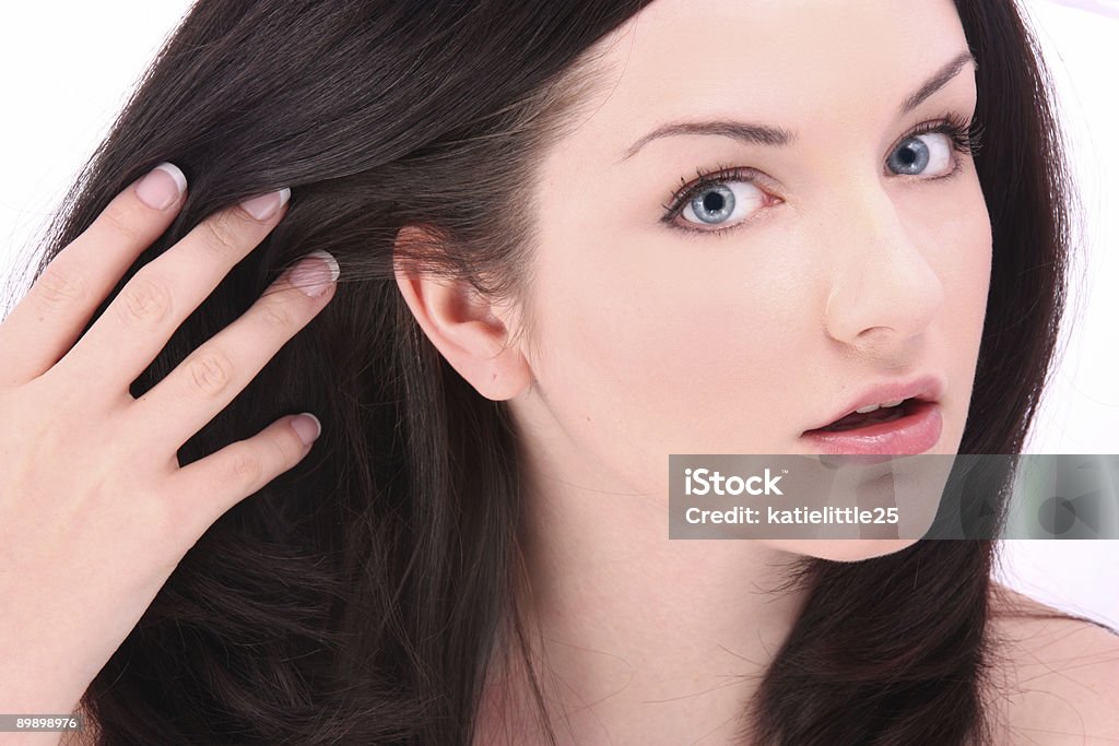 Beautiful brunette touching hair on white  Fingernail Stock Photo