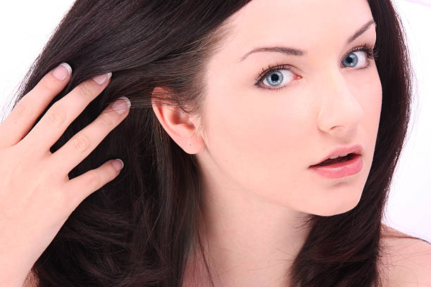 Beautiful brunette touching hair on white stock photo