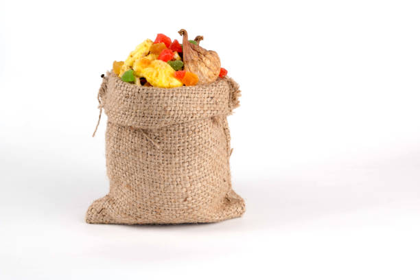 dried fruit - anans, figs, candied fruits in a bag on a white background closeup