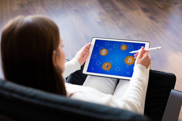 istock Woman holding a tablet with cryptocurrency logos 898994478