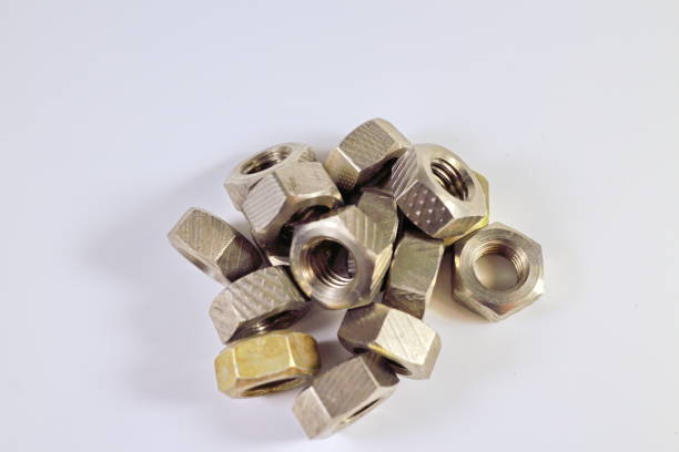 istock shiny silvery yellow metal nuts for bolts on white background 898994874