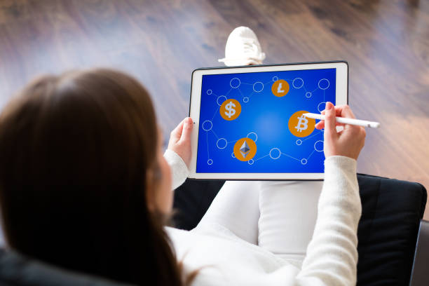 istock Woman holding a tablet with cryptocurrency logos 898994910